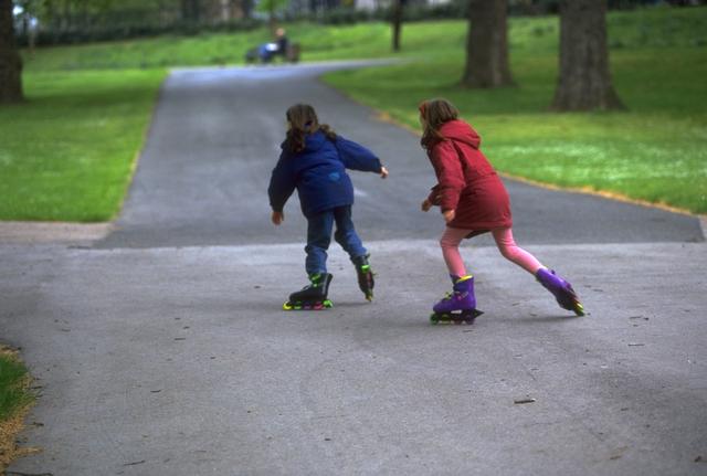Dos niños patinando en un parque